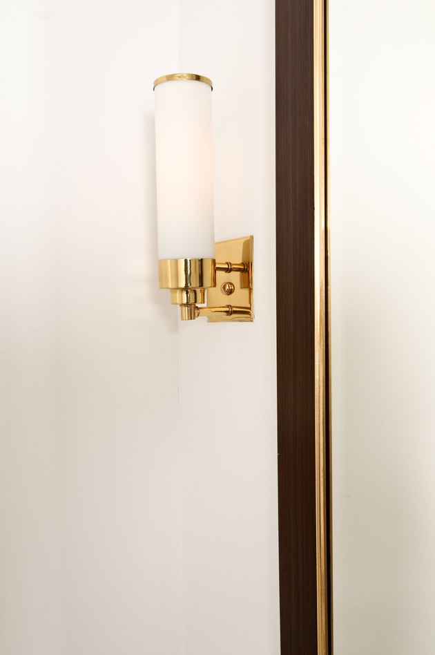 Brass light fixture on wall