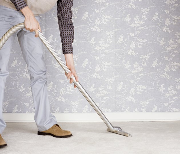 Low Section of a Man Using a Vacuum Cleaner