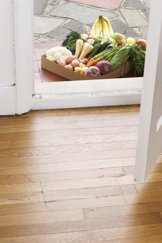 Cardboard box of assorted vegetables at house doors