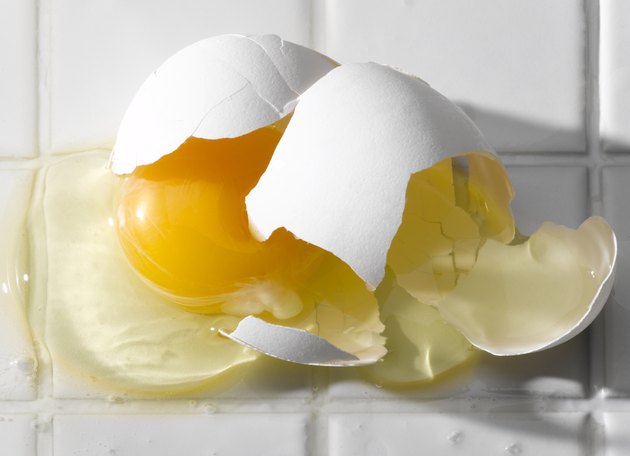 Broken egg on white tiles