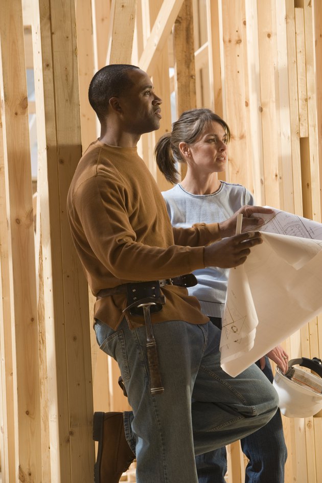 Architects with blueprints at construction site