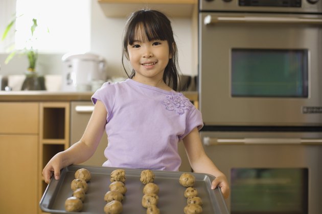 Girl holding cookie sheet