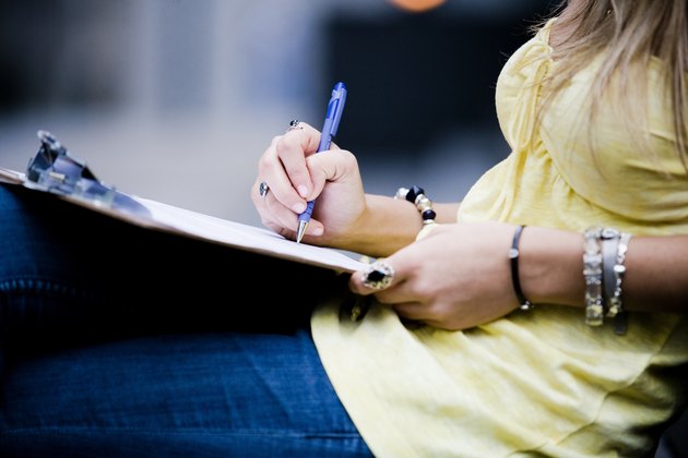 Woman writing on clipboard