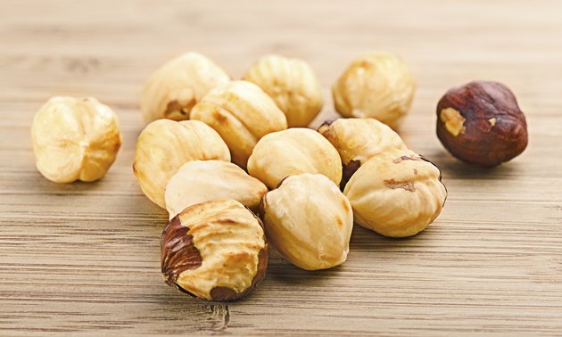 pile of shell-less hazelnuts, isolated on textural wood backgr