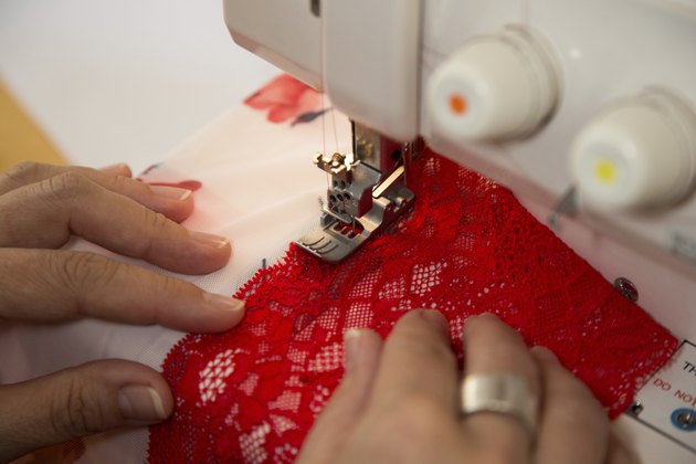 Tailor at sewing machine tailoring lingerie or a bra
