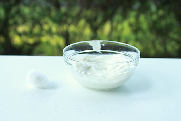 Yogurt face mask in a bowl and a cotton ball