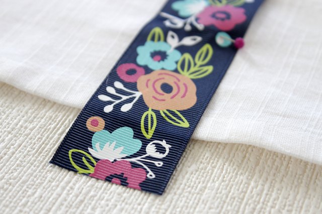 Instead of just hanging your towel over a cupboard door or throwing it on the counter, add a little ribbon to the top so you can give it a place of honor in your kitchen and hang it from your oven door.