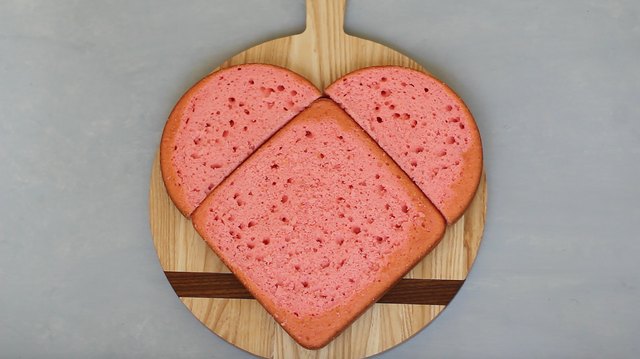 Round cake halves placed above square cake in heart shape