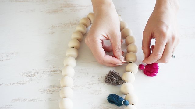 Tying tassels in between wood beads