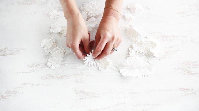 Stringing paper flowers together with a needle