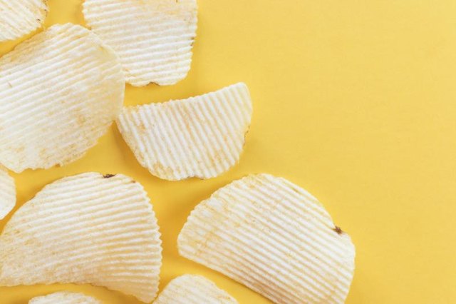 Potato chips flat lay on yellow background