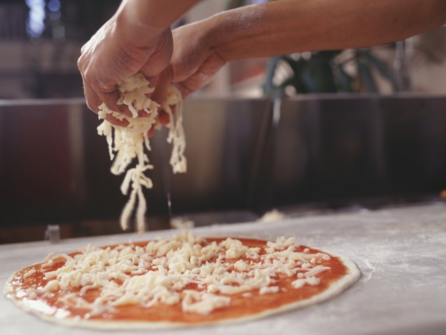 Man making pizza on table, close-up, surface view