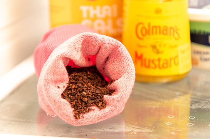 use a sock and coffee grounds to freshen the fridge