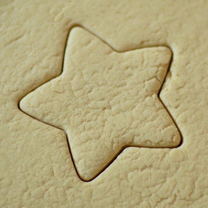 Closeup of rolled-out dough, centered on a star shape made with a cookie cutter