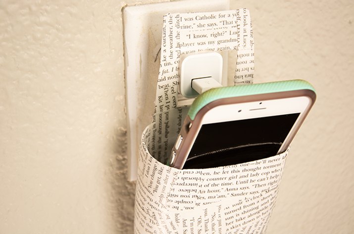 An image of a decoupage phone-charging holder made from an old lotion bottle.