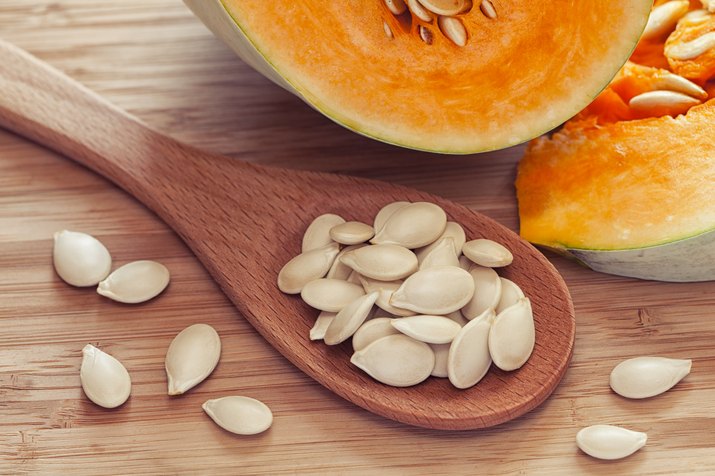 Pumkin seeds inside of wooden spoon