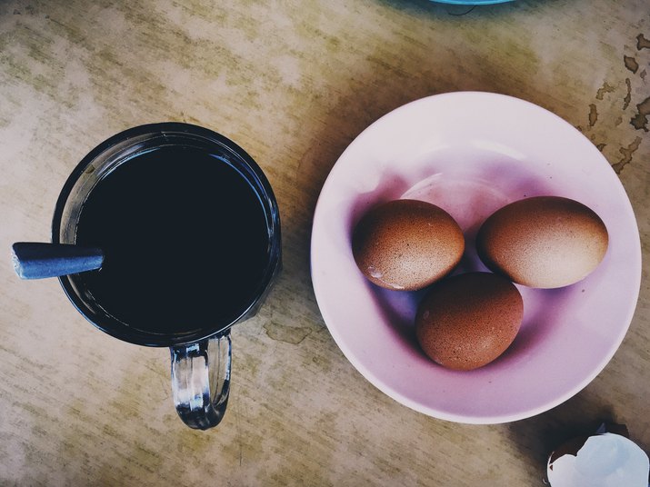 High Angle View Of Black Coffee And Eggs On Table