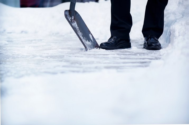 Welldressed man with snow shovel and copyspace