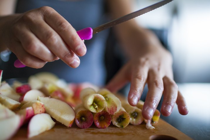 Hands of person cutting apples