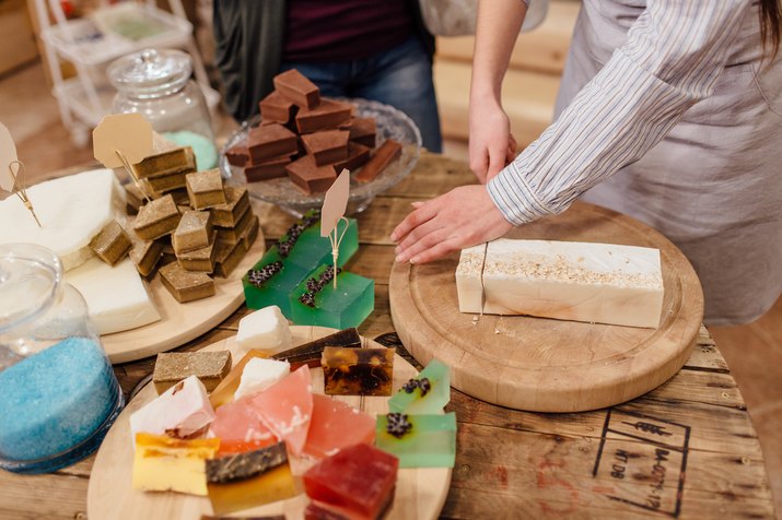 Midsection Of Woman Cutting Soap On Table