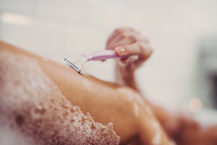 Woman shaving her legs.