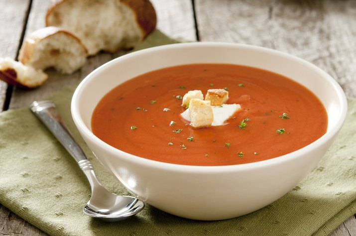 Tomato soup in a white bowl with spoon