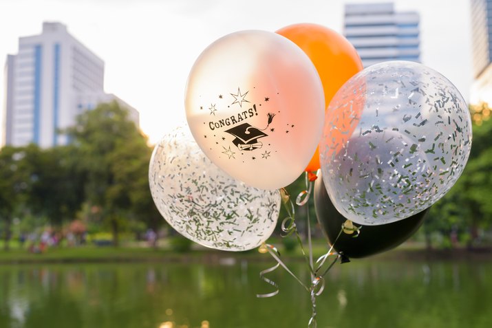 Bunch of decorative balloons for graduation against view of Lumpini Park in Bangkok Thailand