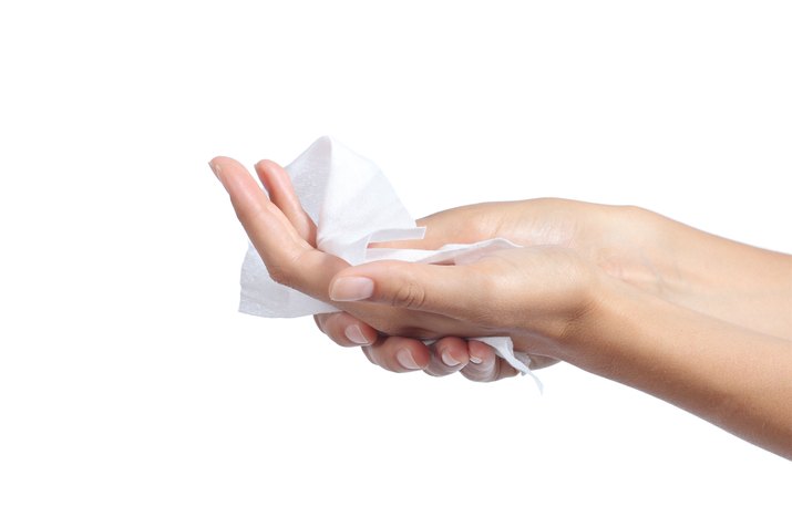 Woman cleaning her hands with a tissue