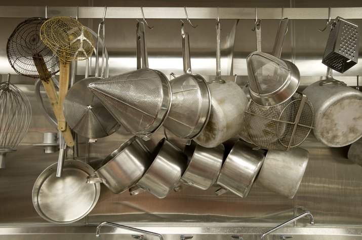 A full pot rack in a commercial kitchen 