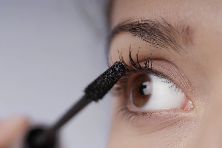 Close-up of a young woman applying mascara