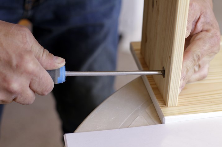 Midsection of man assembling furniture