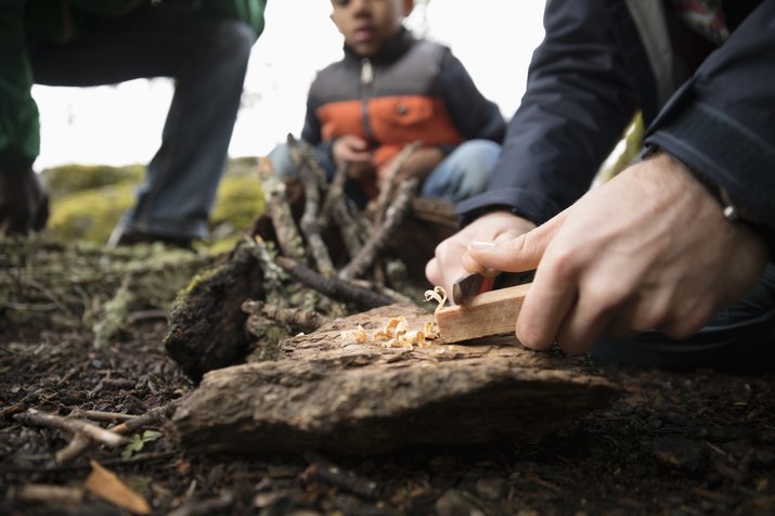 Man preparing campfire in woods