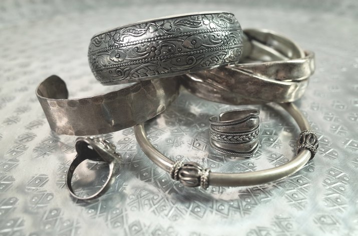 Close-Up Of Silver Jewelry On Patterned Table