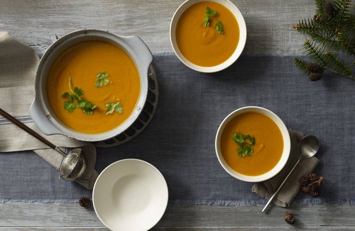 A table filled with bowls of butternut squash soup.