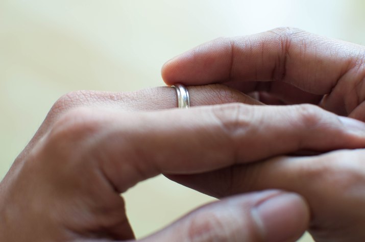 A man is holding his wedding ring