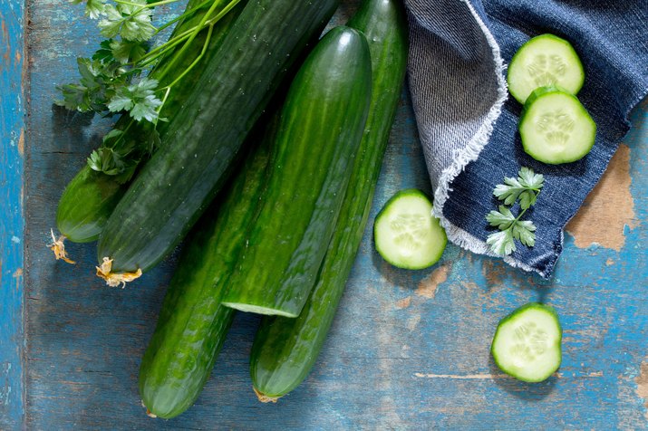 Fresh organic cucumbers on a wooden table, top view.