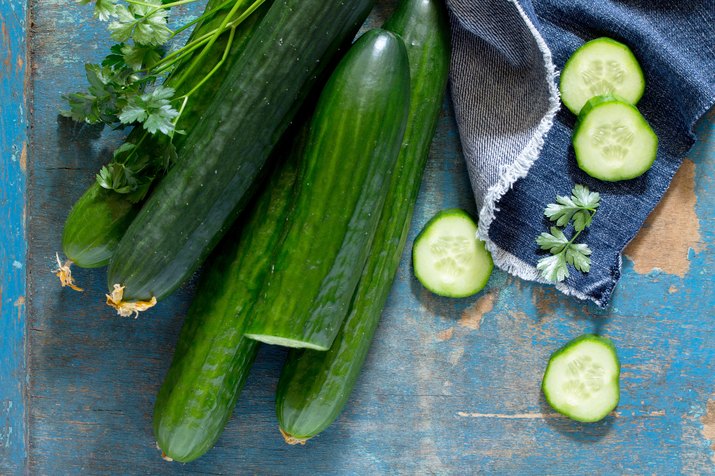 Fresh organic cucumbers on a wooden table, top view.