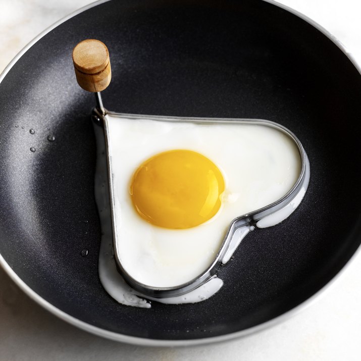 Heart-shaped egg in frying pan with mold