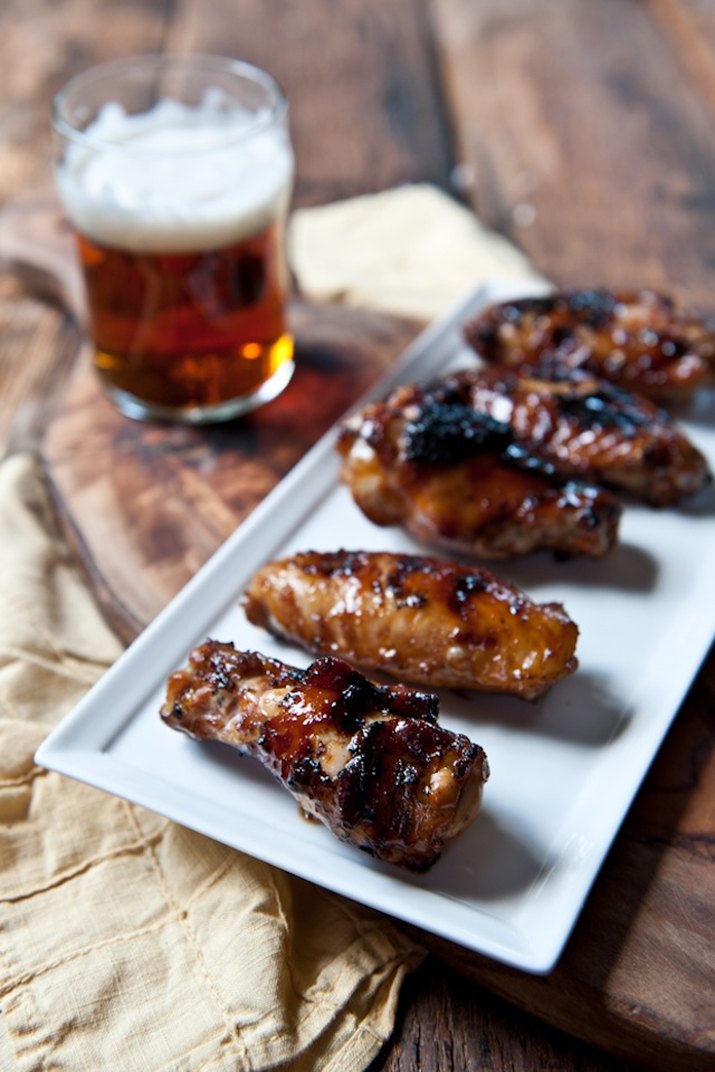 Dish with honey stout chicken wings with a glass of beer.