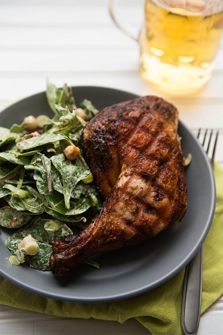 Dish with grilled chicken and a chickpea and spinach side salad.