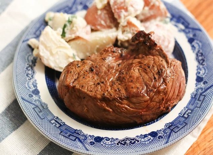 Dish with grilled top sirloin and potato salad.