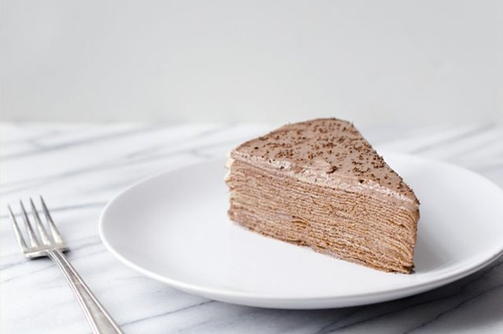 A fluffy, light brown Nutella crepe cake slice.
