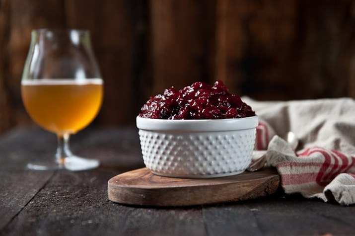 A dish filled with orange winter ale cranberry sauce, served with a beer.