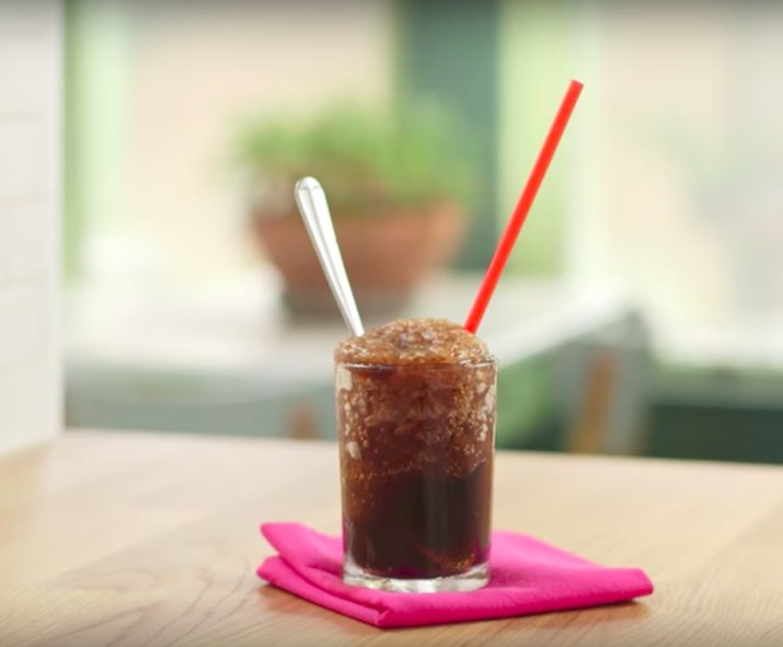 Cola slush in glass with straw