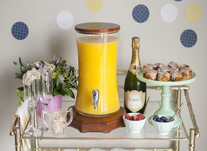 Glass bar cart with components for do-it-yourself mimosas.