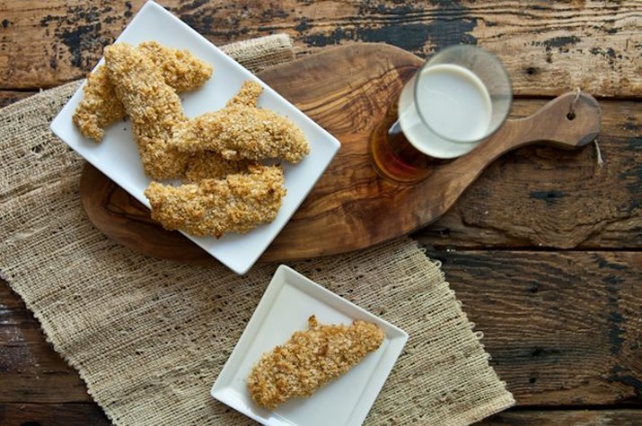 A plate of crisped oven-fried beer and buttermilk chicken served with a beer.