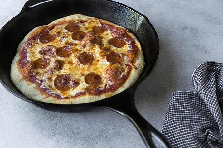 A pizza cooked in a black cast iron skillet