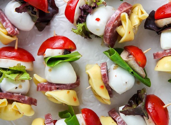 A colorful plate of readily assembled Italian antipasti skewers.