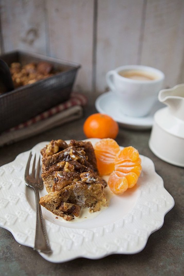 A slice of  French toast breakfast bake served with tangerines and coffee.