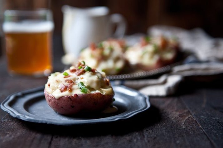 A plate with a freshly made twice-baked red potato with creamy beer cheese.